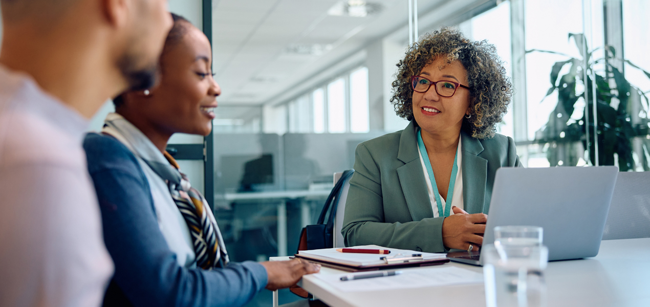 Businesswoman meeting with a couple in an office.