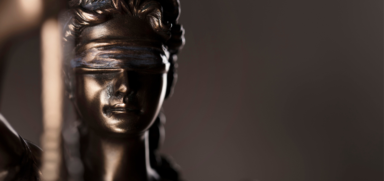 Gros plan sur une statue en bronze de la Justice.
