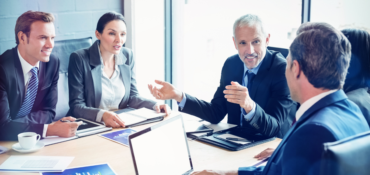 Man shaking hands with businessman beside woman.
